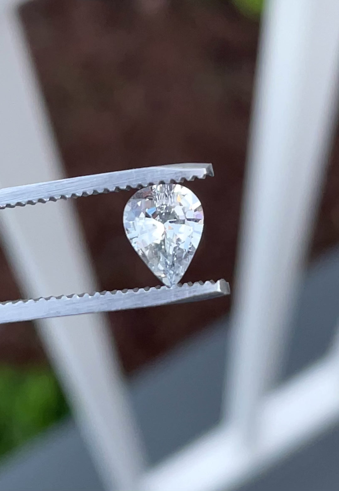 Close-up video of a 1.18-carat unheated sapphire from Sri Lanka, pear-cut with pastel and gray hues, rotating to reveal light reflection and clarity.