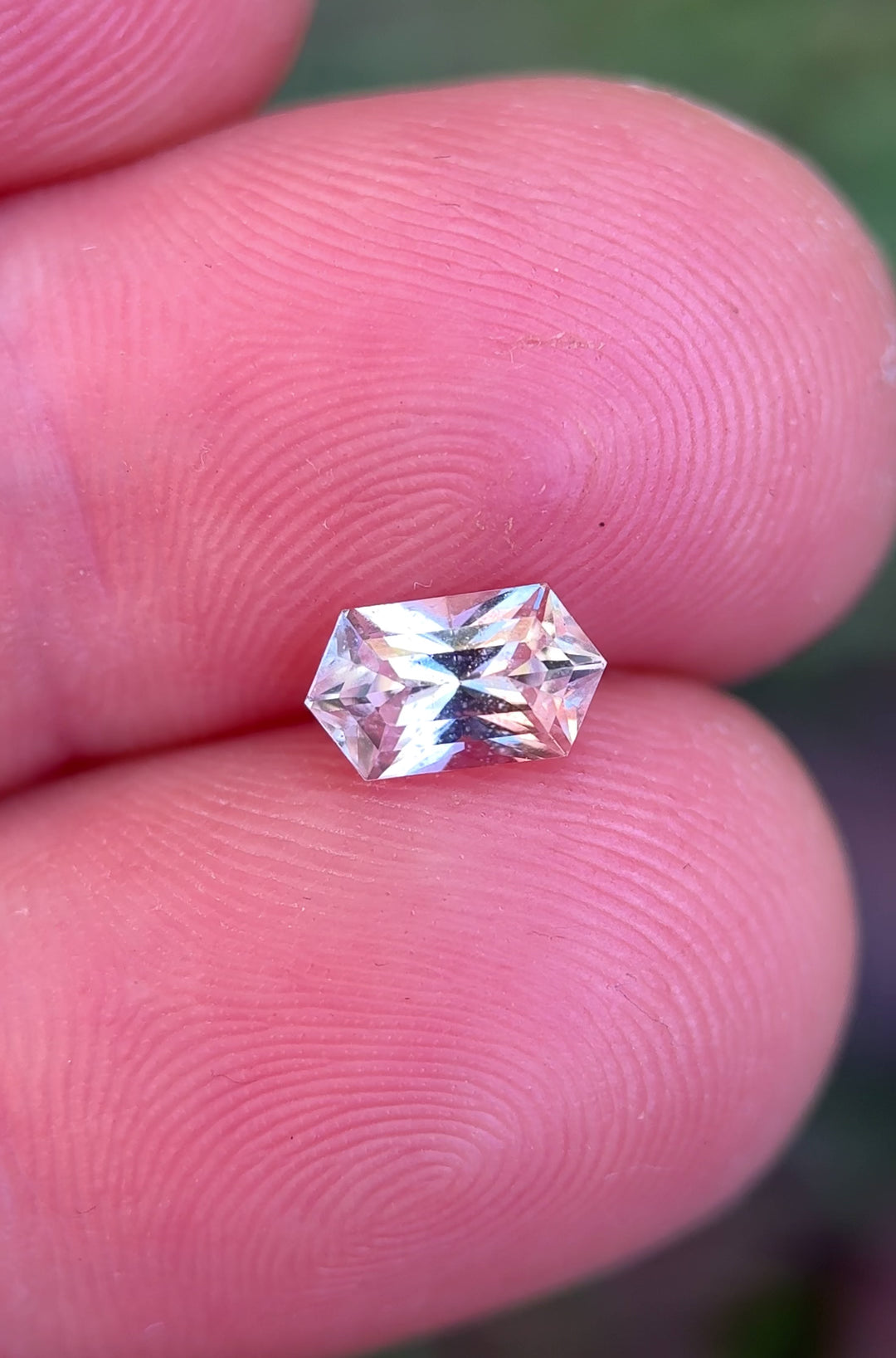 Peach pink sapphire moving in natural light highlighting brilliance and soft pastel tones.