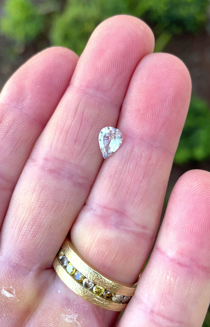 Video showcasing the 1.18-carat pastel seafoam gray pear sapphire under natural light, highlighting its brilliance and soft color transitions.