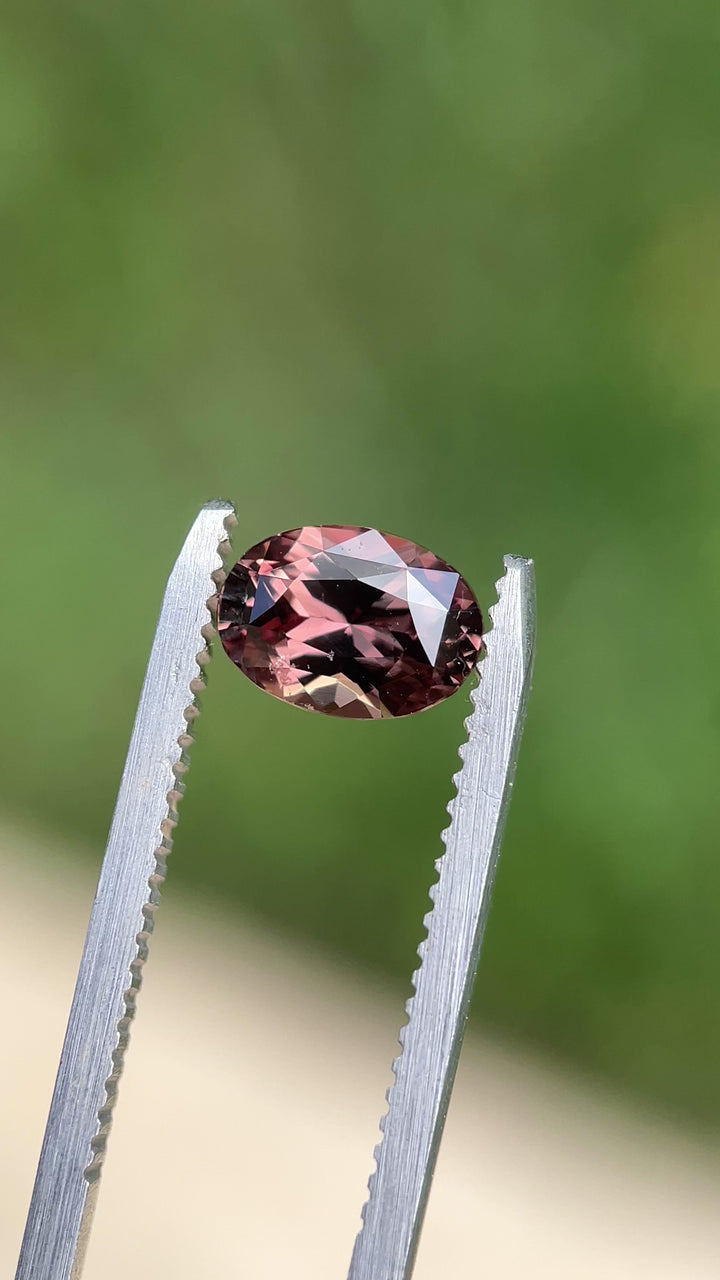 Video showcasing a 1.68-carat color-change sapphire, capturing the shift between purplish pink and brownish pink under different lighting conditions.