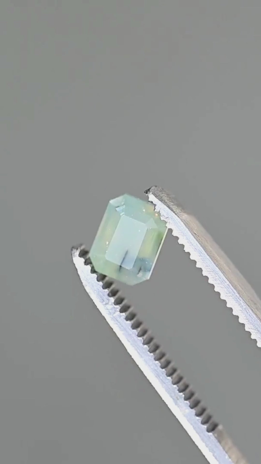 A closer look at the broad step facets, clipped corners and delicate teal-blue parti color of this untreated 1.88ct Nigerian sapphire. Its softly translucent interior reveals the natural features that make this gemstone unique.