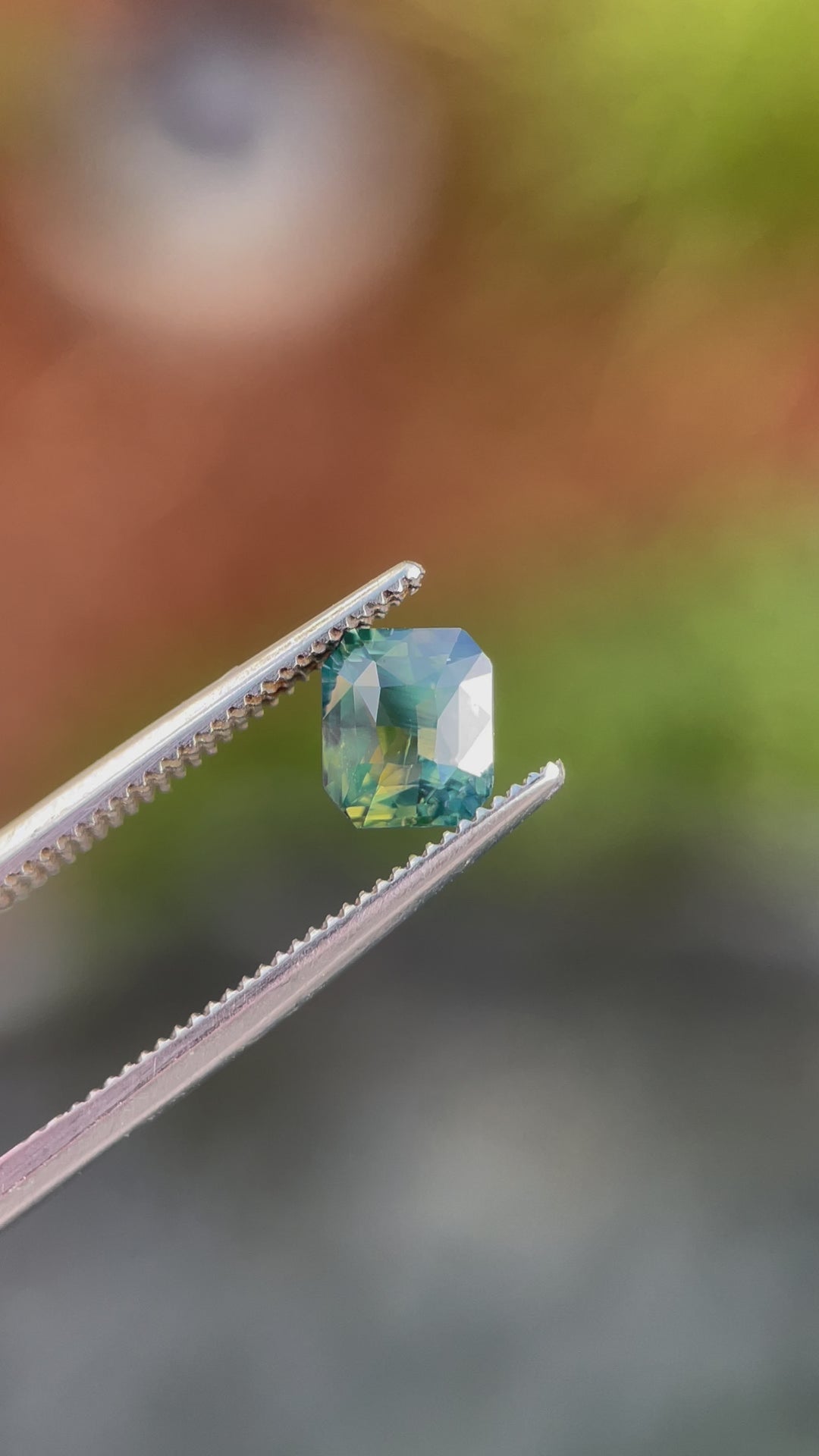 A 360-degree video showcasing the brilliance and opalescent hues of a 1.42-carat radiant-cut sapphire. Featuring yellow, teal, and green tones, the gemstone is ethically sourced from Madagascar and untreated.