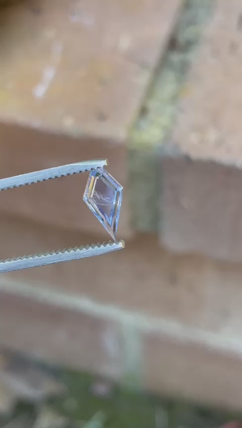 Video showcasing a 1.18-carat custom step cut portrait kite sapphire in a pastel cornflower blue color, capturing the gemstone’s brilliance and precision craftsmanship from different angles.