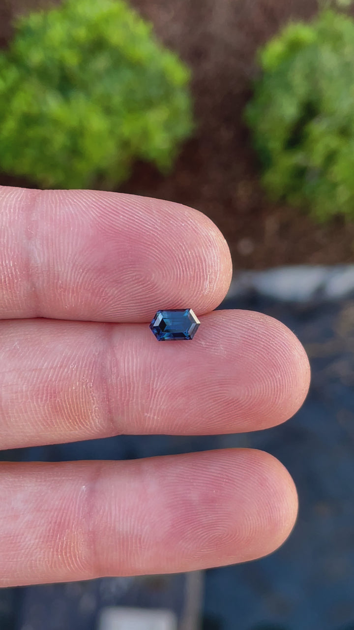 Close-up video of a 1.31-carat emerald-cut sapphire from Gombe, Nigeria, displaying its mesmerizing green and blue tones with an elegant step-cut.