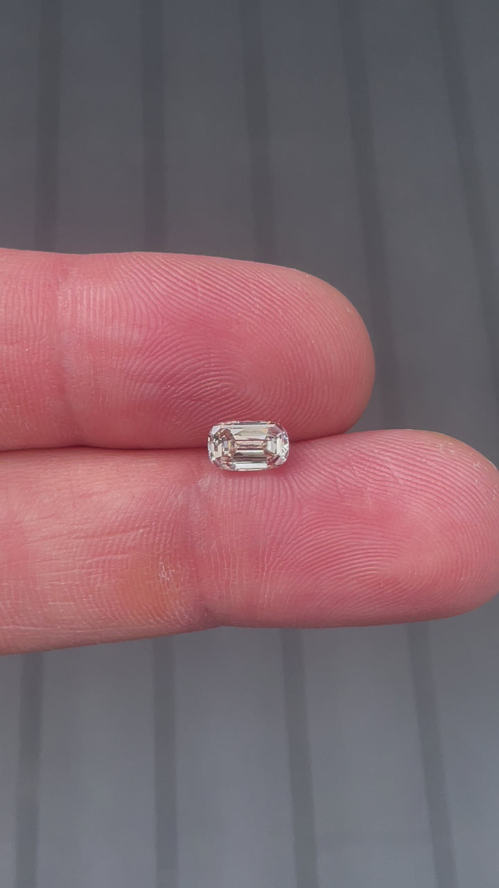 Detailed view of a 1.03-carat VS2 clarity diamond with a fancy yellowish brown color, emphasizing its antique-inspired elongated step cut and South African origin.