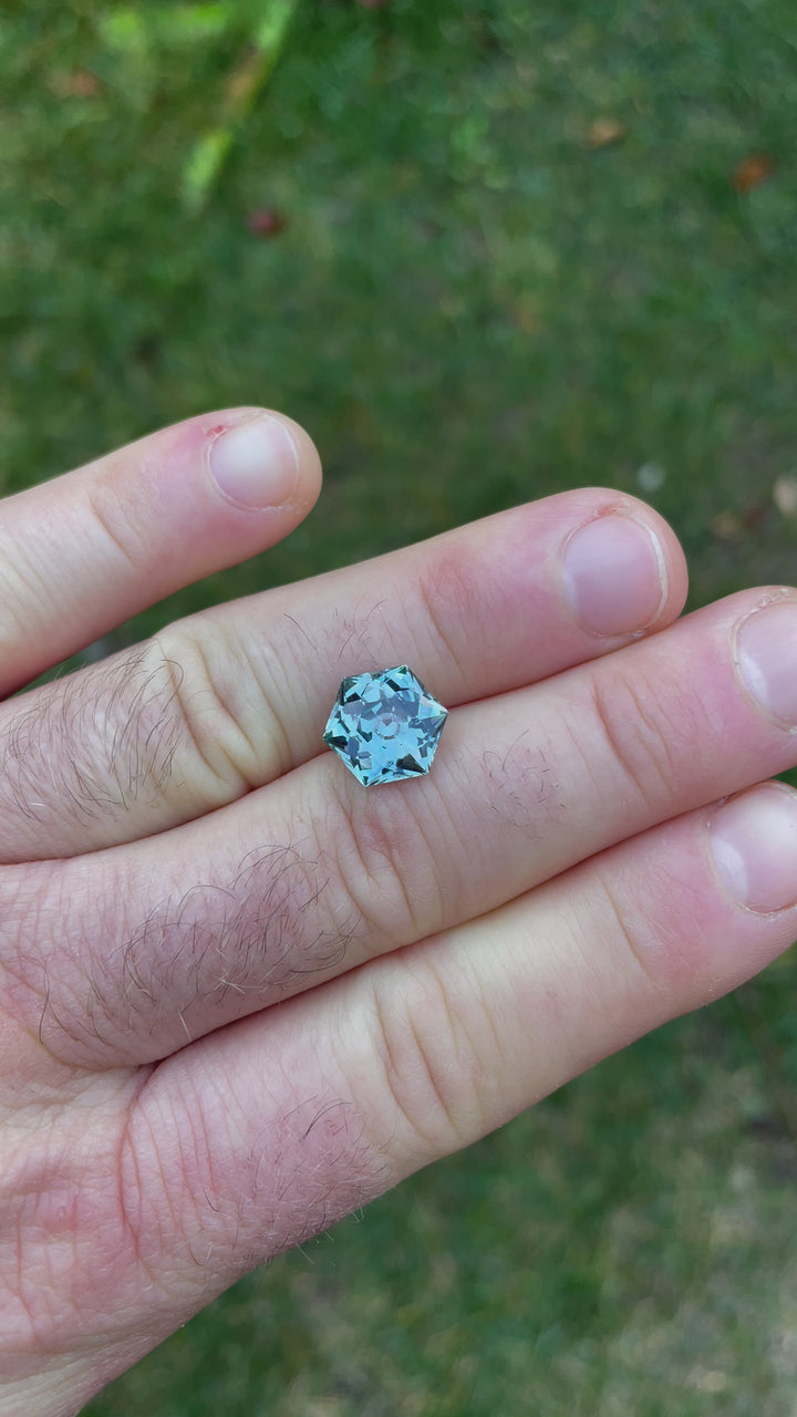 Outdoor video presenting a 5.79-carat hexagonal modified brilliant sapphire in a natural setting, highlighting how sunlight plays off its surfaces to reveal the depth of its green and blue colors.