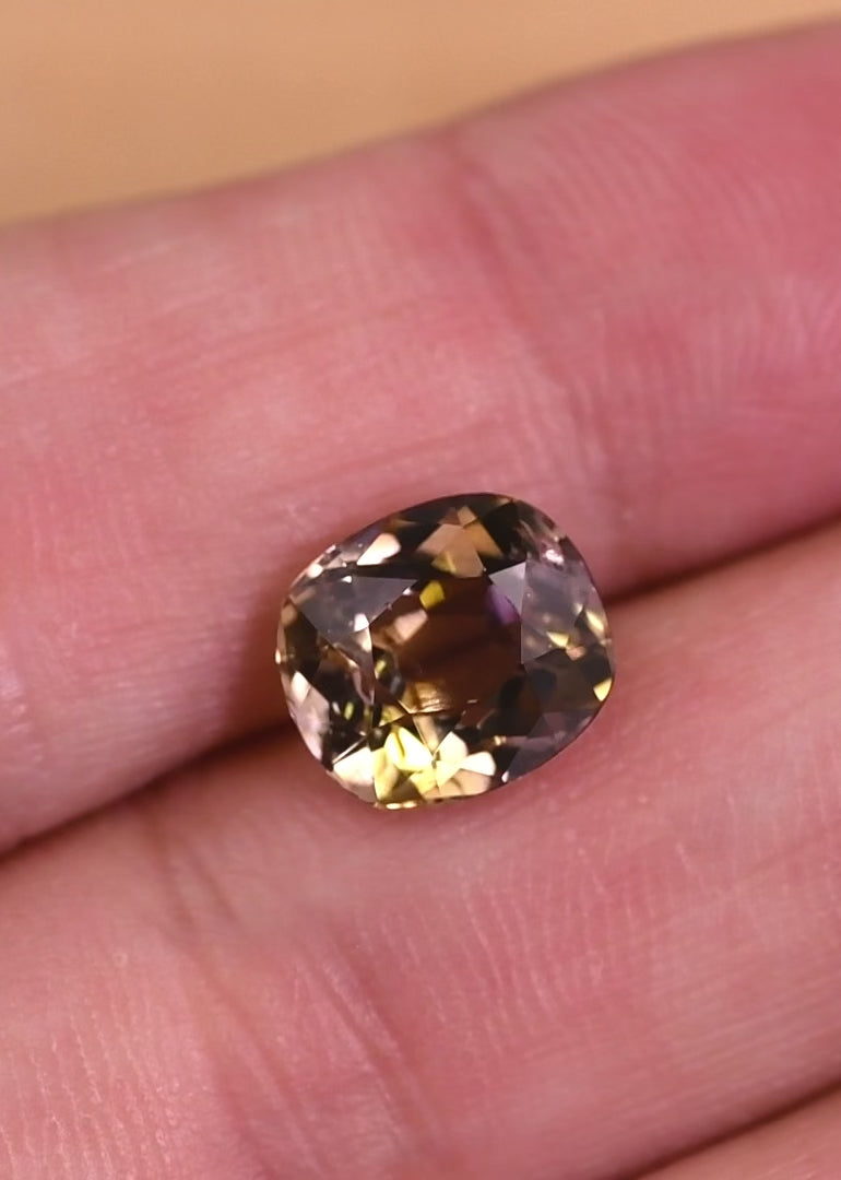 Macro video capturing light performance and color shift in a 3.27 carat natural tanzanite, highlighting purple, pink, and peach hues in a custom old mine cut, untreated gemstone from Merelani Hills Tanzania