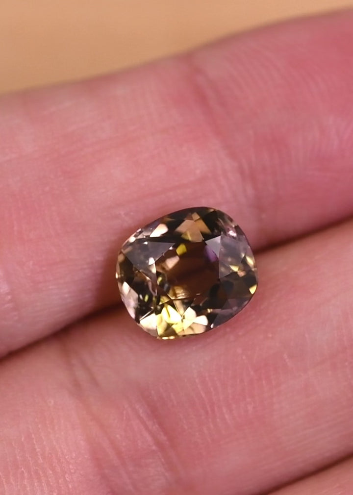 Macro video capturing light performance and color shift in a 3.27 carat natural tanzanite, highlighting purple, pink, and peach hues in a custom old mine cut, untreated gemstone from Merelani Hills Tanzania