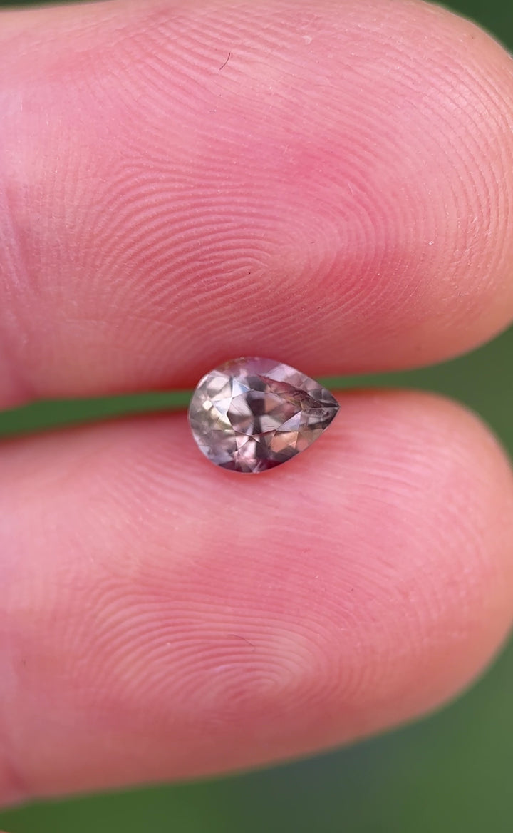Rotating view of Umba River sapphire showing natural color change from soft mauve to vivid reddish hues