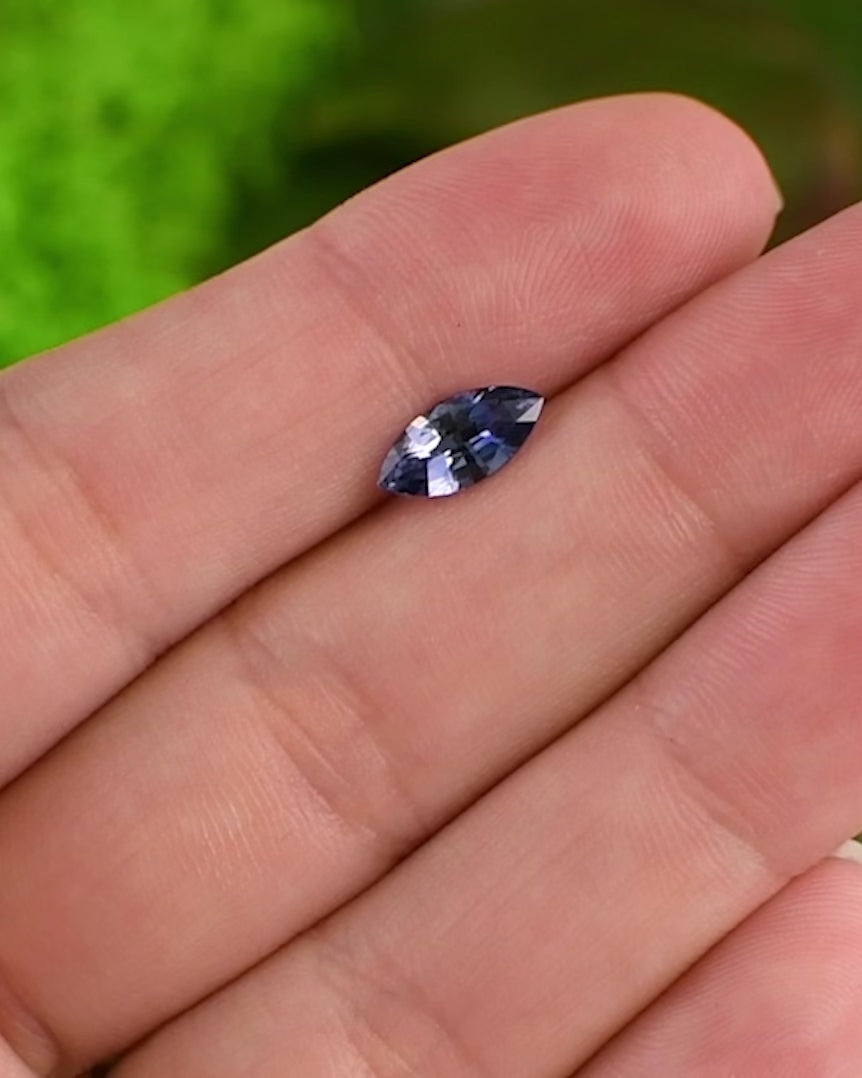 Close-up video of 1.24 carat vivid blue sapphire on fingertip, capturing gemstone’s depth of color and sparkle in daylight, precision marquise mixed cut, untreated sapphire from Sakaraha, Madagascar.