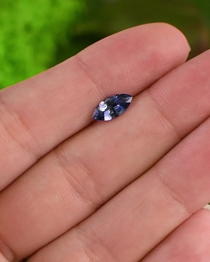 Close-up video of 1.24 carat vivid blue sapphire on fingertip, capturing gemstone’s depth of color and sparkle in daylight, precision marquise mixed cut, untreated sapphire from Sakaraha, Madagascar.