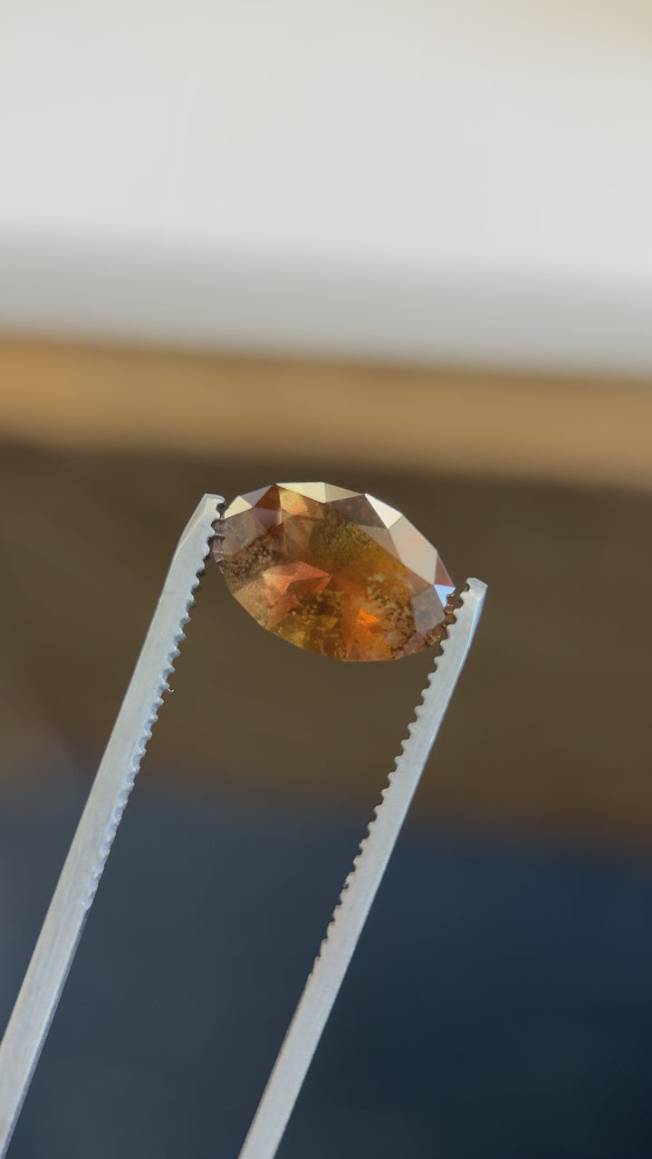 Macro video of Tanzanian sapphire showing full color shift from golden-orange to earthy brown and green in real time