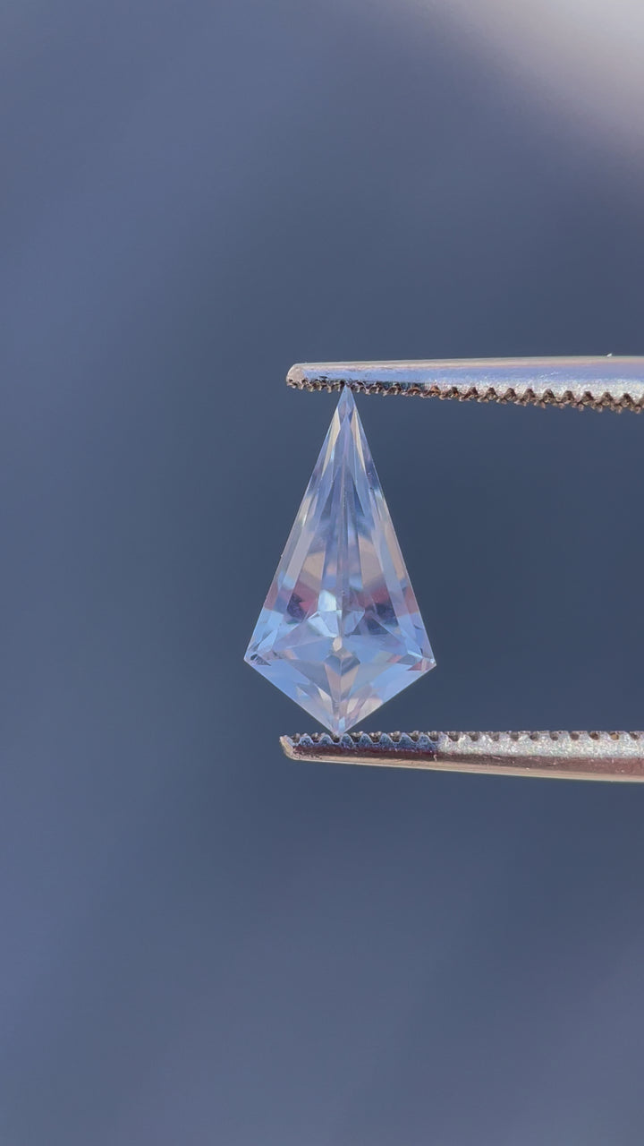 Engaging video showcasing a 1.66 carat periwinkle and powder blue sapphire, geometric step cut kite shape, demonstrating its clarity and vibrant color, sourced from Sri Lanka.