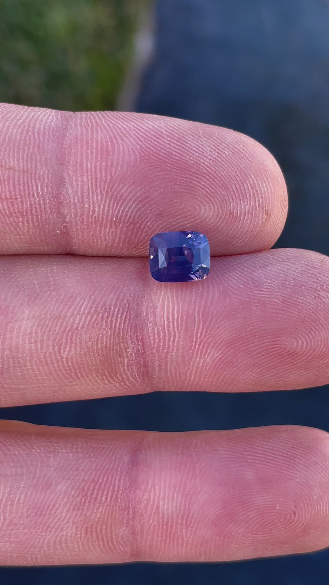 A mesmerizing video of a cushion-cut sapphire weighing 2.56 carats, featuring mauve and purple tones, with light playing off its facets.