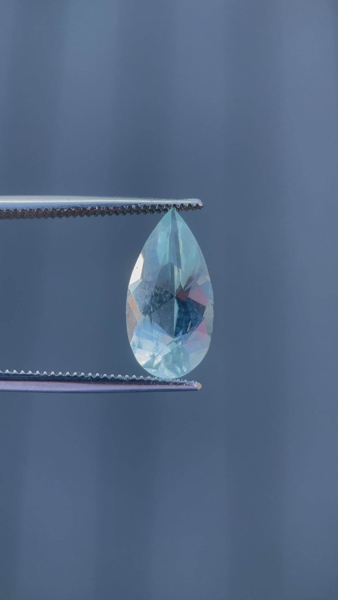 Video showcasing the brilliant sparkle and green mint blue hues of a 3.88-carat aquamarine gemstone in a custom pear cut as it is rotated under light.
