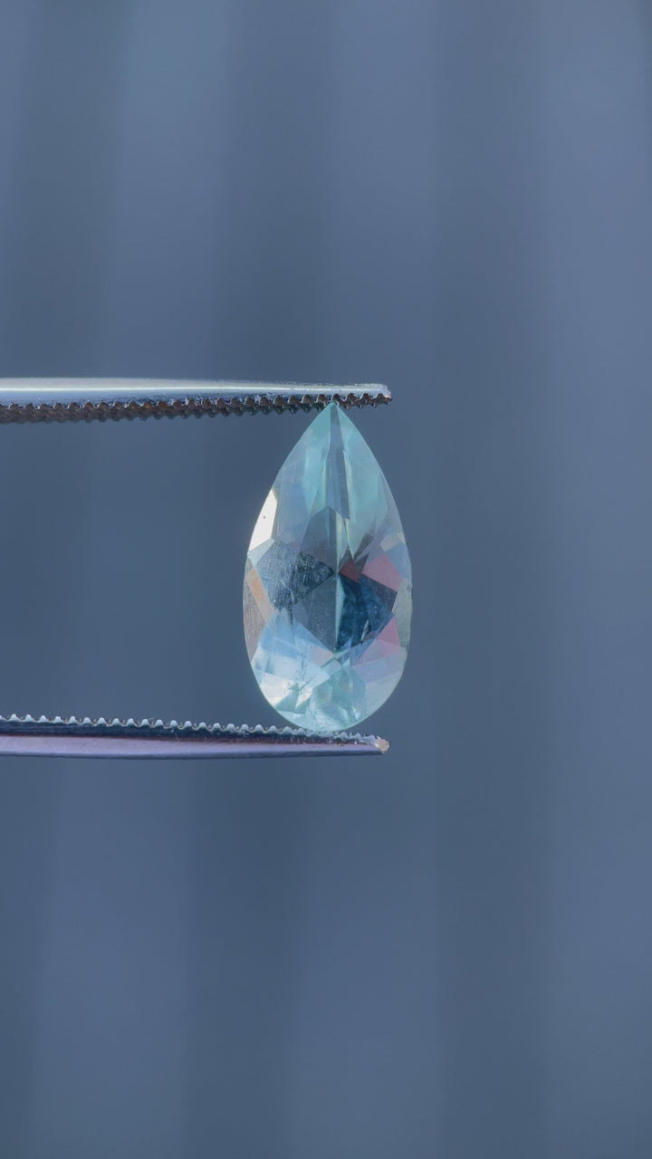 Video showcasing the brilliant sparkle and green mint blue hues of a 3.88-carat aquamarine gemstone in a custom pear cut as it is rotated under light.