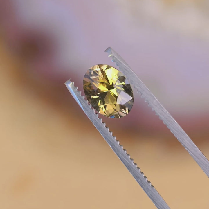 Close-up video of untreated 1.68 carat Tanzanite oval turning under light, revealing green and yellow tones from Merelani Hills, Tanzania