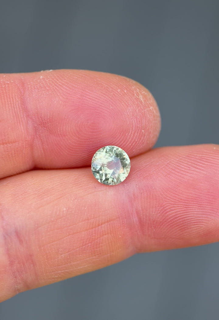Handheld video of untreated 1.42ct Umba River sapphire under natural light – antique round cut displays teal, yellow, and green flashes.