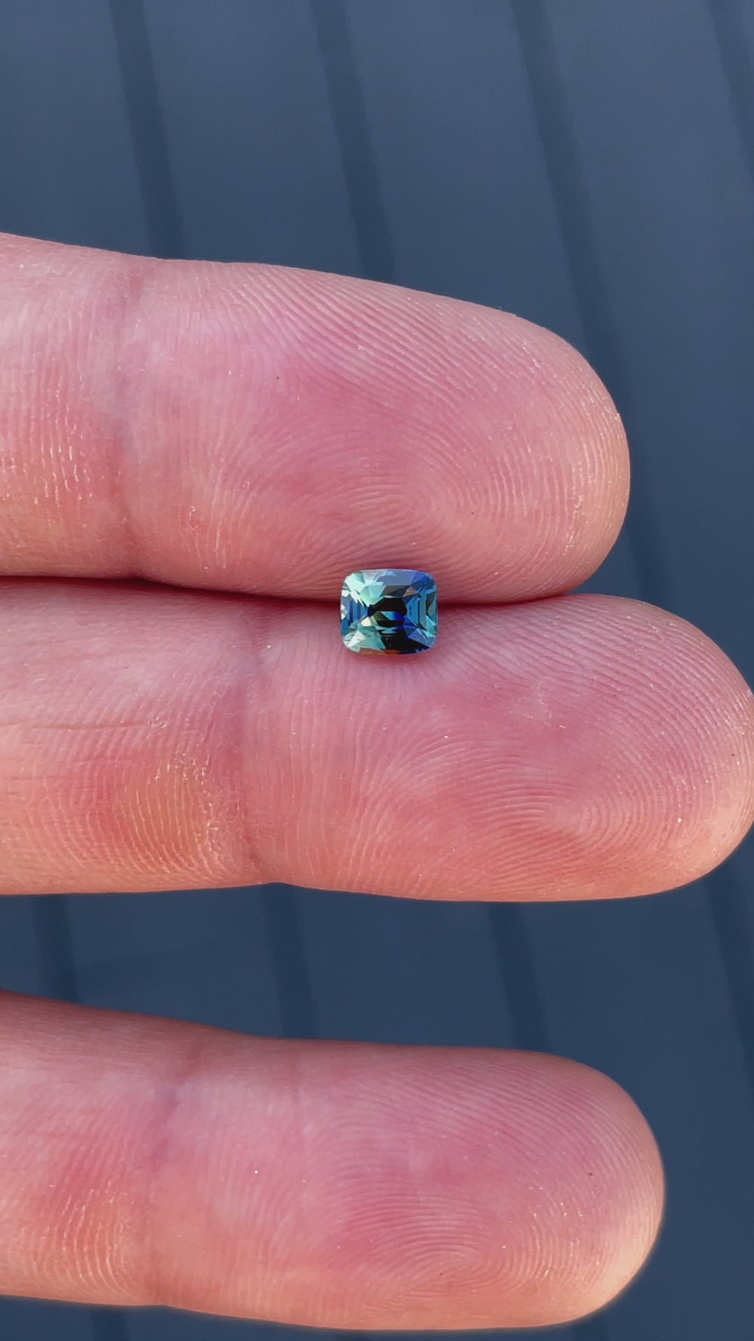 Video showcasing the brilliance and clarity of a 1.02-carat blue and yellow sapphire in a cushion cut, capturing its sparkle from different angles.