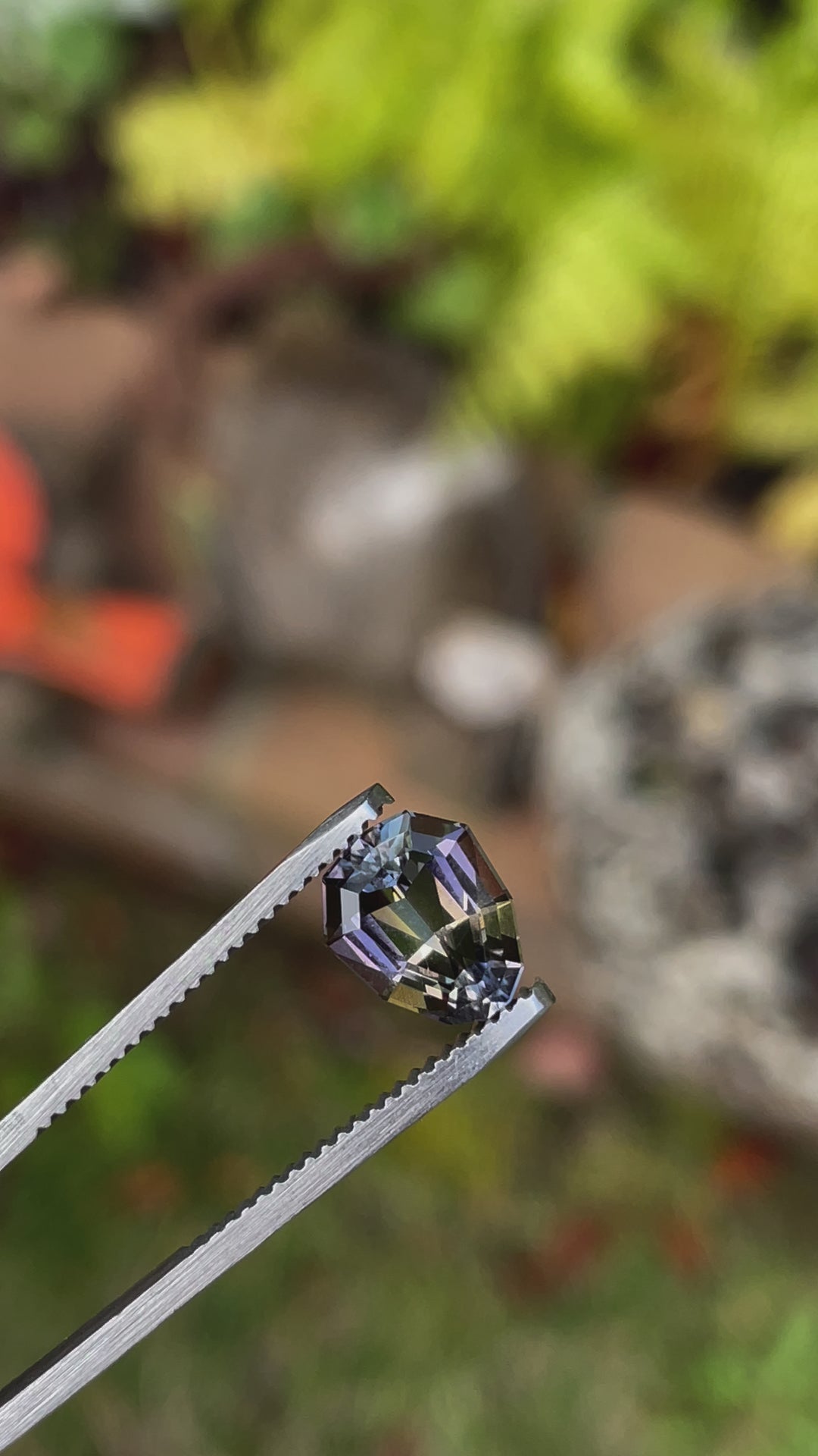 Video displaying a 2.10 carat Tanzanite gemstone rotating in tweezers, showcasing its unique geometric pear shape and mesmerizing color transitions between purple, yellow, and green. This high-quality Tanzanite is from Merelani Hills, Tanzania, celebrated for its natural and untreated appearance.