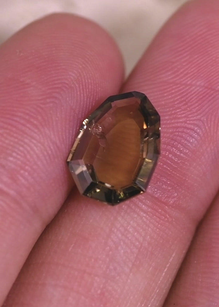 Close-up video of a pink-purple-peach Tanzanite shield portrait cut gemstone in hand, showing depth, internal character, and color play in an untreated Tanzanian 3.20CT gem