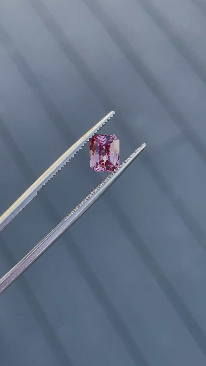 A detailed rotating view of a 1.45-carat peach champagne garnet, showcasing its modified octagonal step cut and stunning natural tones.