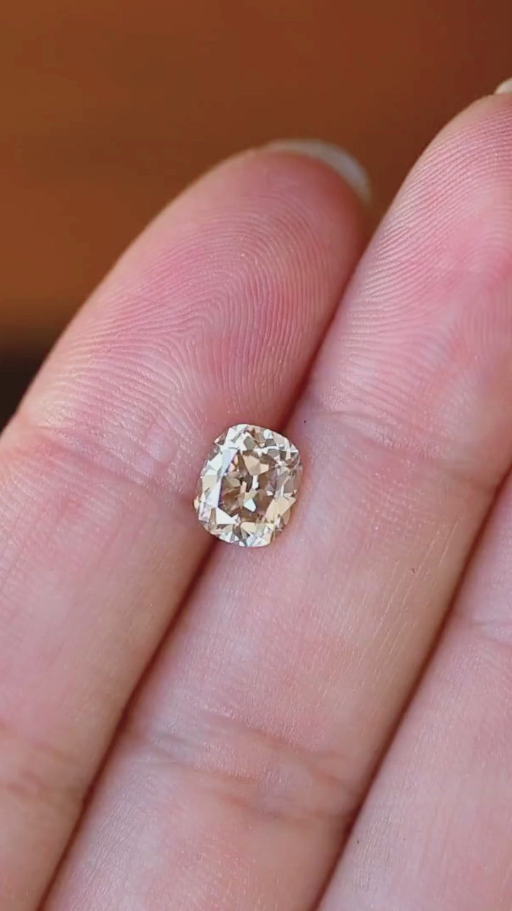 See the face-up scale and warm color of this 1.64ct untreated South African champagne diamond. Its Old Mine Cushion Cut creates an antique-inspired silhouette with lively, varied reflections—an individual center stone for a custom engagement ring.