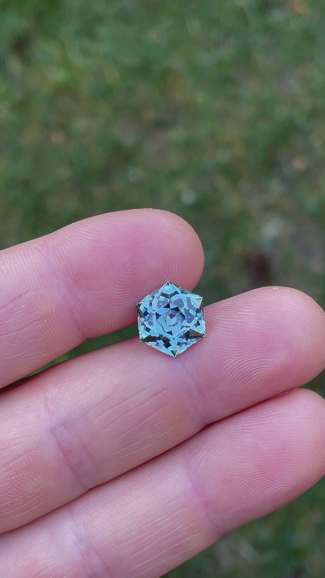Video capturing the detailed examination of a 5.79-carat hexagonal modified brilliant cut sapphire, focusing on its clarity, color depth, and the intricate facets that reflect its unmatched quality