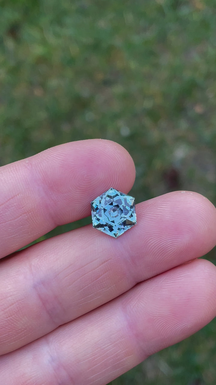Video capturing the detailed examination of a 5.79-carat hexagonal modified brilliant cut sapphire, focusing on its clarity, color depth, and the intricate facets that reflect its unmatched quality
