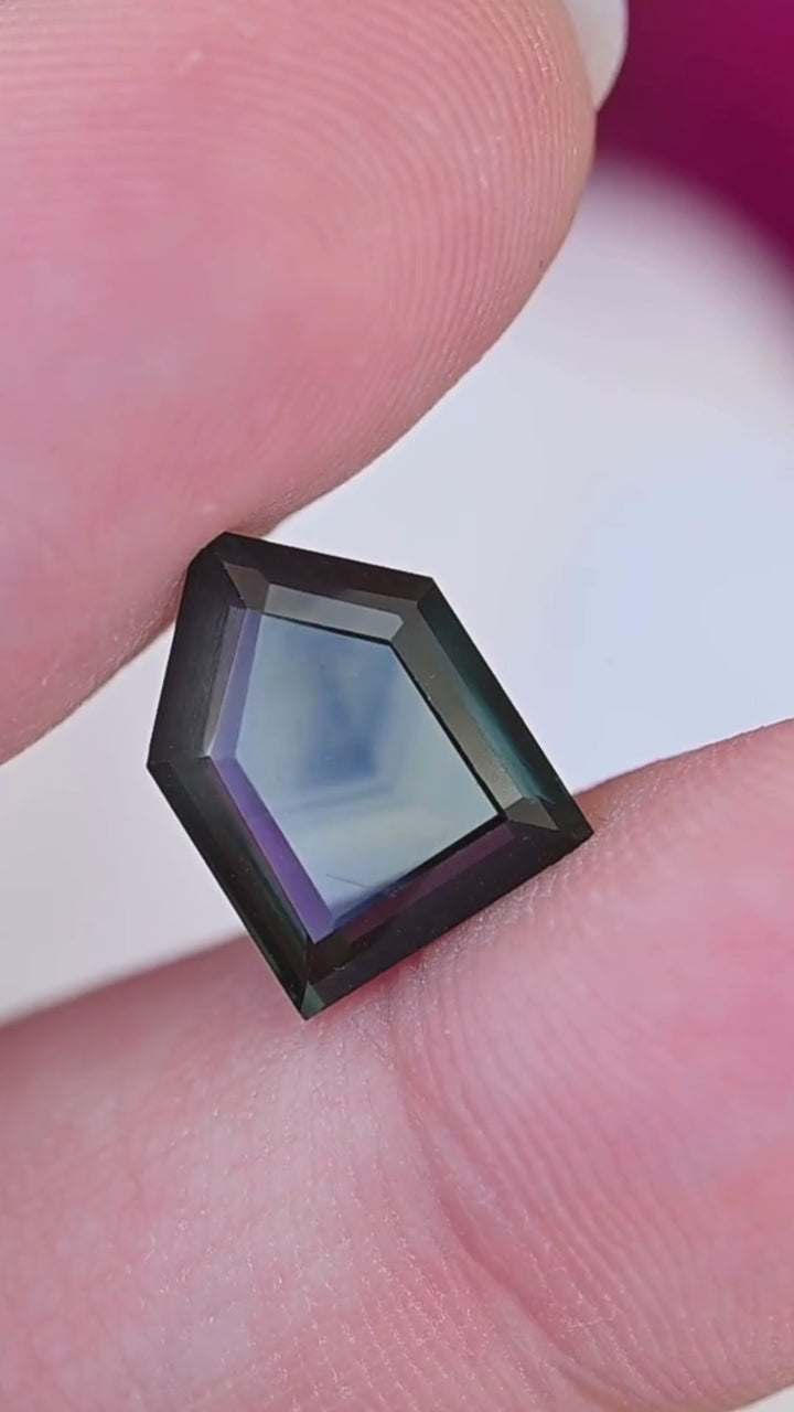 View the scale, geometric silhouette and shifting blue-green appearance of this untreated 3.68ct Nigerian sapphire, featuring a custom shield portrait cut.