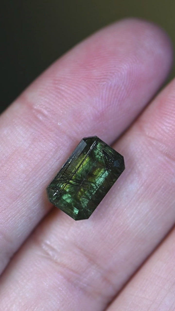 Experience this natural untreated Skardu peridot in hand as its layered forest green tones, elongated step mix cut, and distinctive internal crystal structure come to life from every angle.