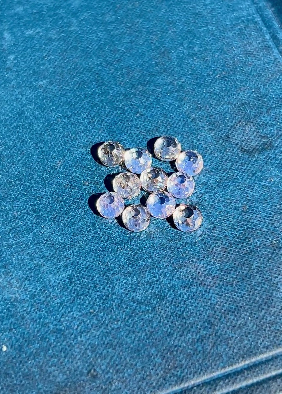 Video of antique Mughal cut diamonds rotating under light to reveal open culets, light blue fluorescence, and hand-cut facets in a 5.20 carat fancy light brown VVS diamond parcel from South Africa
