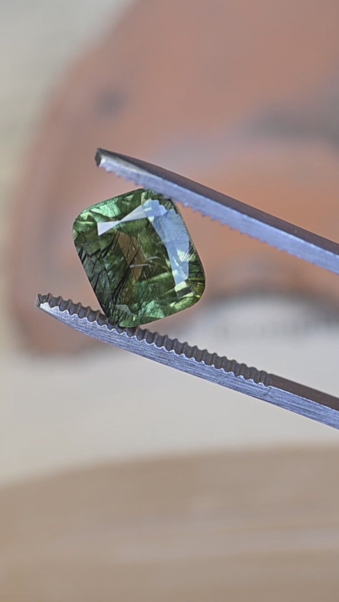 Watch this untreated 5.49 carat Pakistan peridot rotate in natural light, revealing its soft sage green color, cushion mix cut, and remarkable natural needle inclusions.