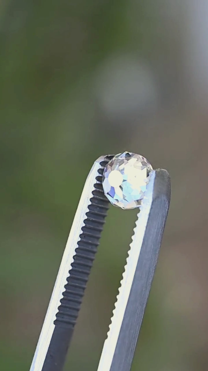 Untreated 1.92 carat round Mughal cut diamond rotated between jeweler’s tweezers, showing the open central table, broad historic-inspired facets and shifting flashes of light from multiple angles.