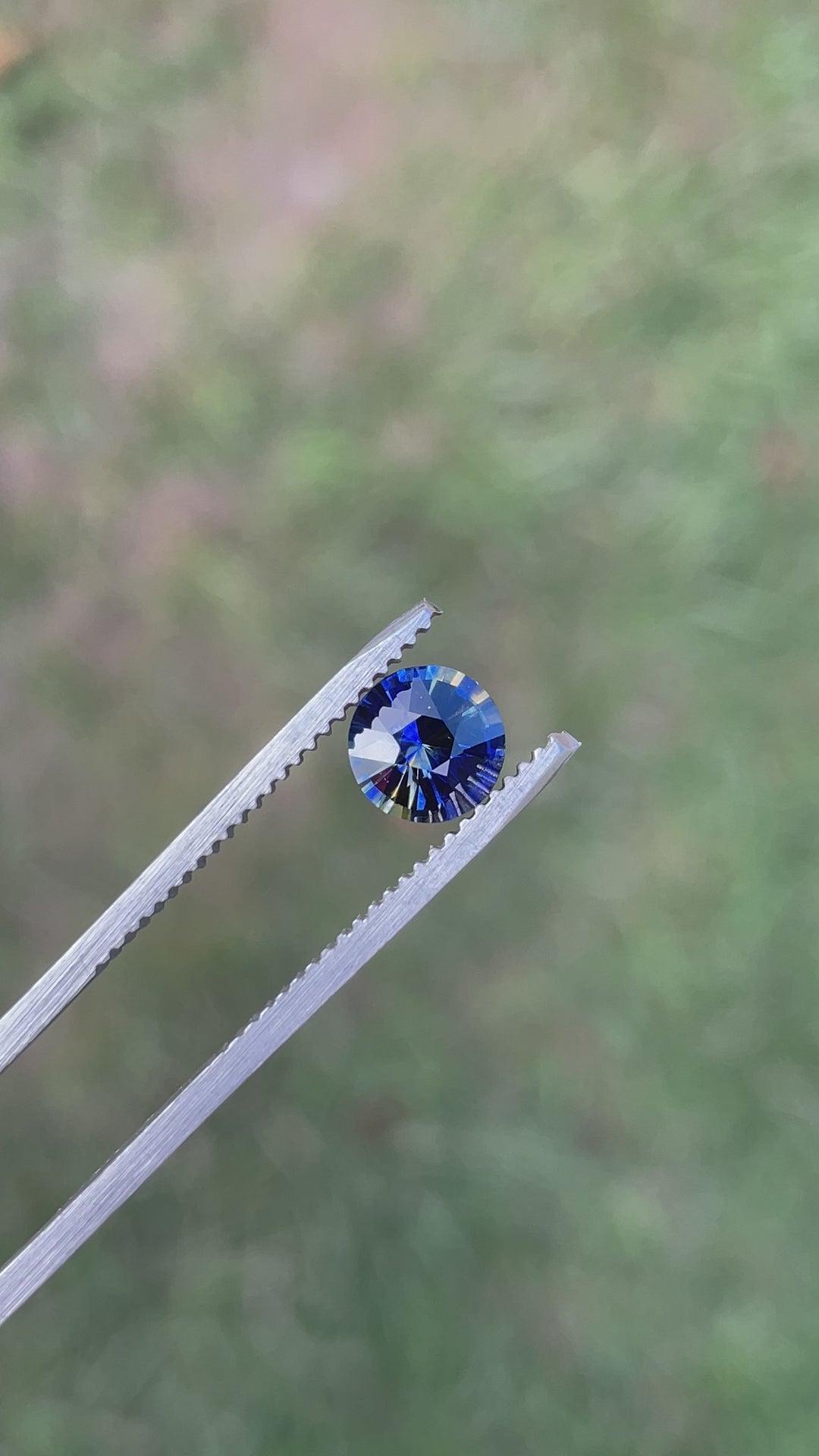 Rotating video of a 1.11-carat round brilliant parti sapphire, highlighting its vivid color zoning and brilliant sparkle from different lighting angles.