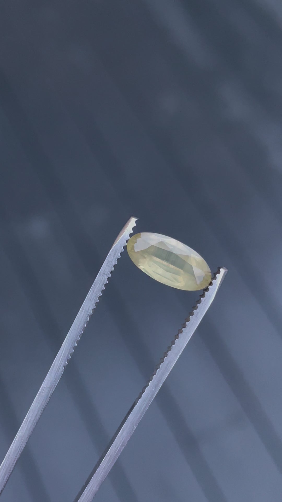 Detailed video examination of a 1.93 carat peach sapphire, focusing closely on its custom cut and the opalescent play of colors across its surface.