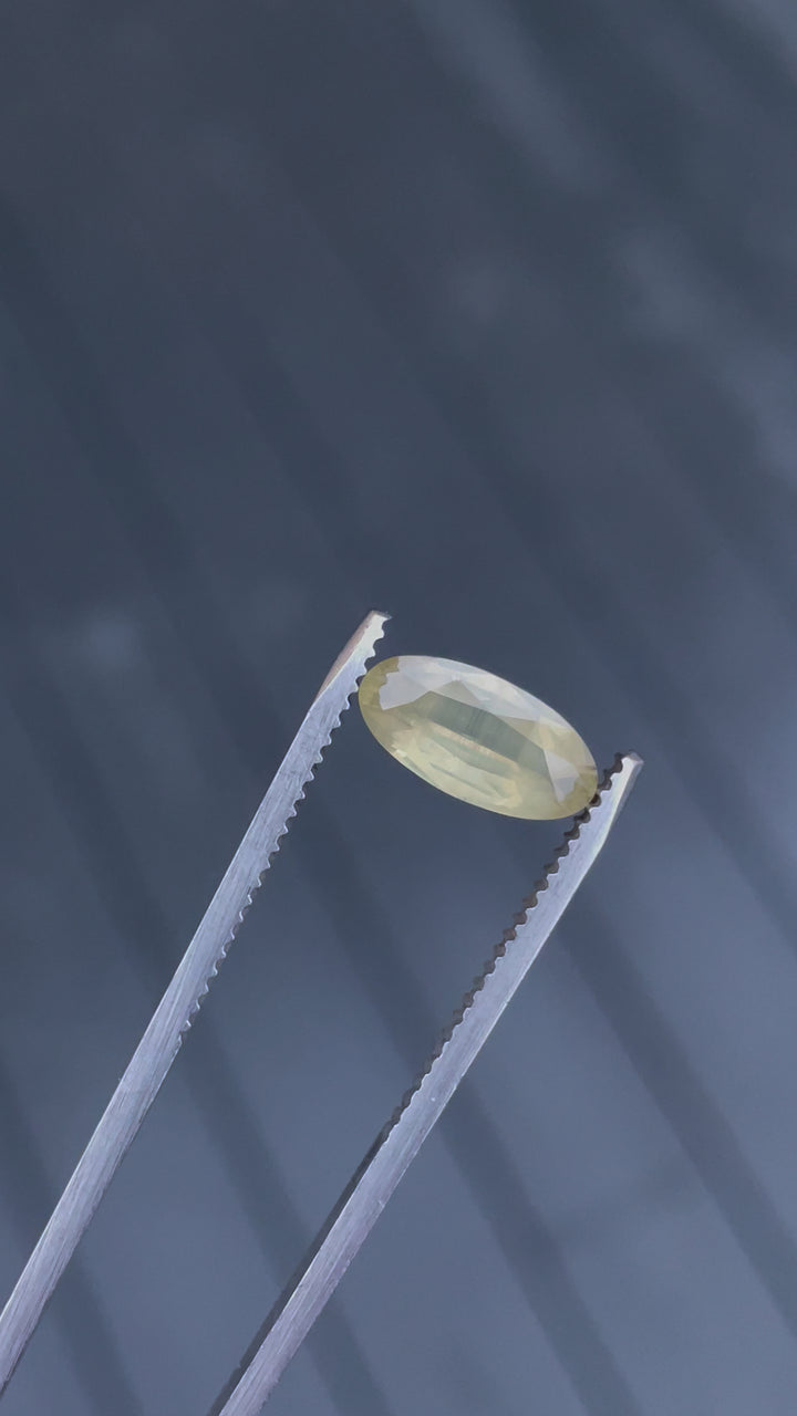 Detailed video examination of a 1.93 carat peach sapphire, focusing closely on its custom cut and the opalescent play of colors across its surface.