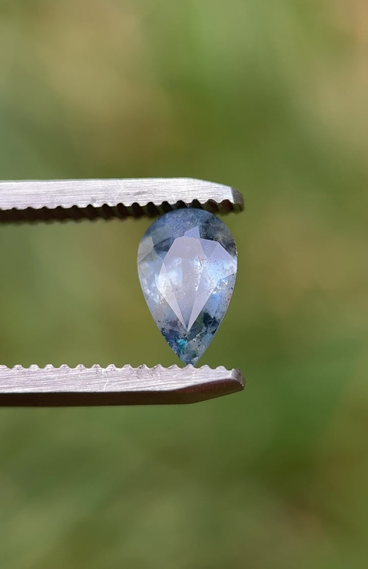 Macro video of 1.30 carat periwinkle blue sapphire from Umba River Valley, Tanzania, rotating in tweezers to showcase its natural inclusions, pear mix cut shape, and unheated blue brilliance.