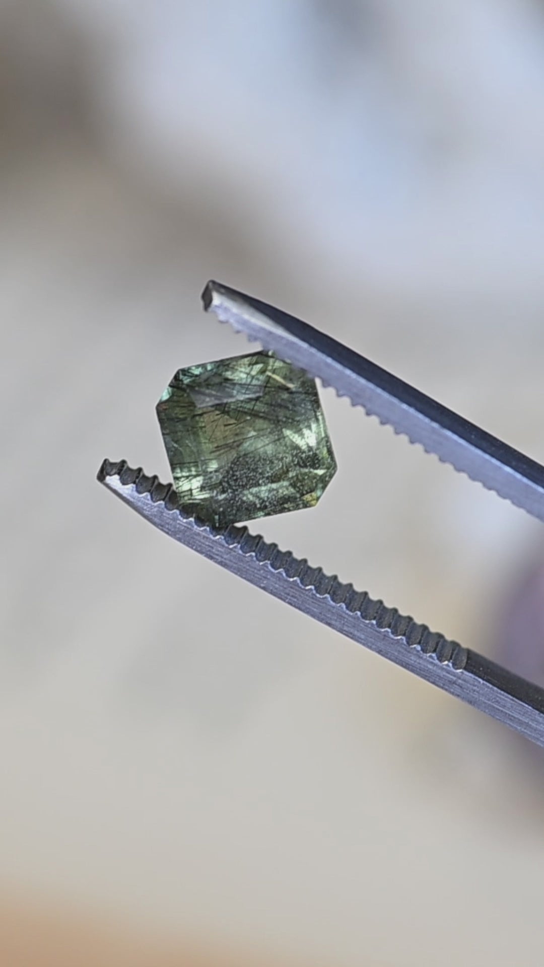 Watch this untreated 2.89 carat Pakistan peridot rotate in natural light, revealing its soft sage green color, precision custom Asscher cut, and intricate natural needle inclusions.