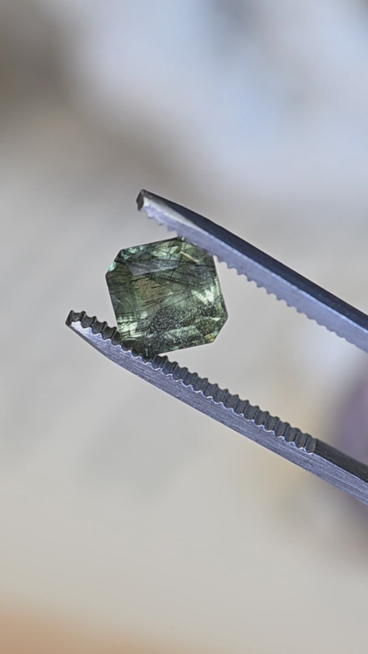 Watch this untreated 2.89 carat Pakistan peridot rotate in natural light, revealing its soft sage green color, precision custom Asscher cut, and intricate natural needle inclusions.