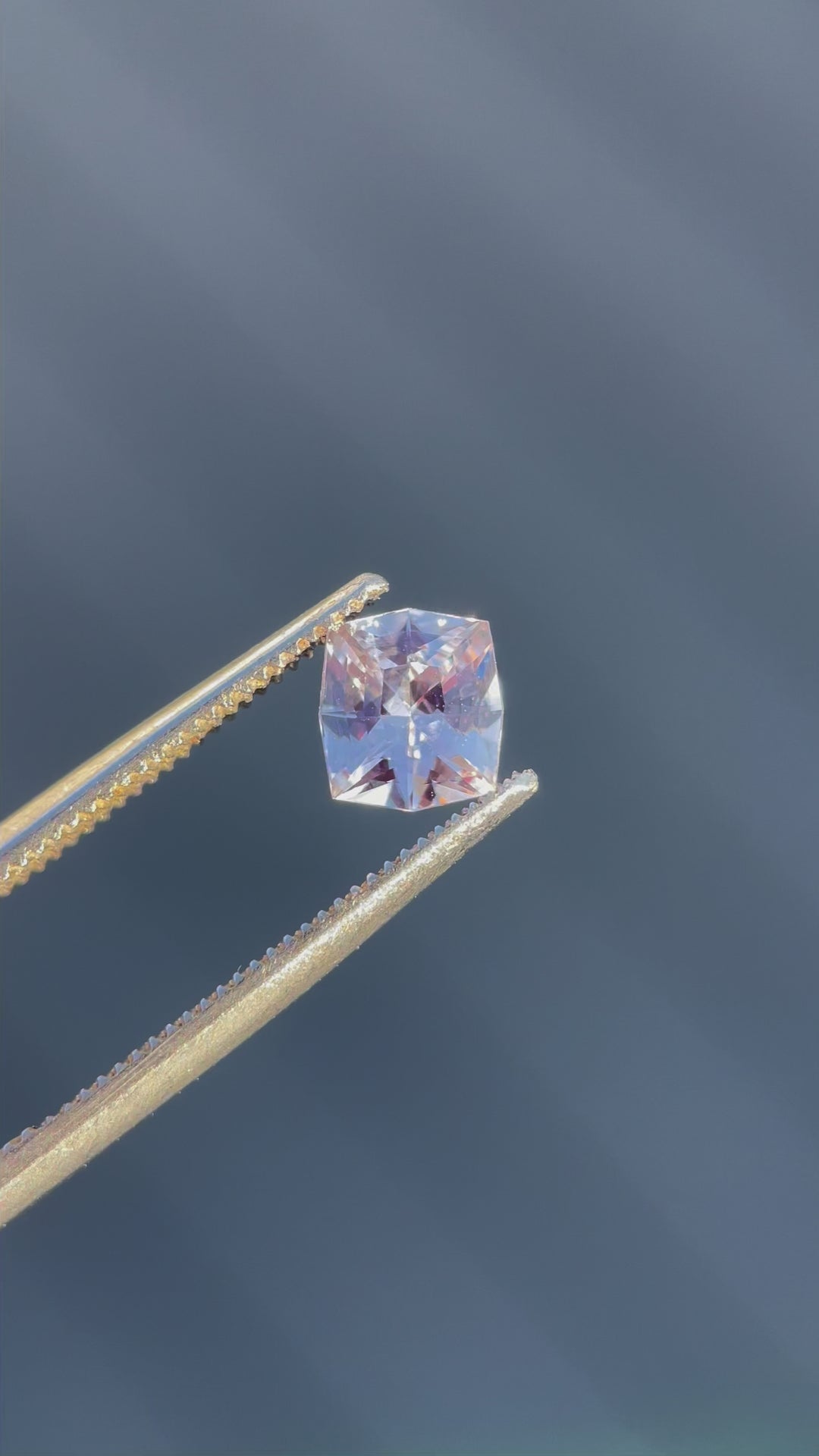 A detailed 360-degree video showcasing the vibrant pink peach hues and fancy cushion cut of a 1.04-carat sapphire, captured to emphasize its brilliance and untreated origin.