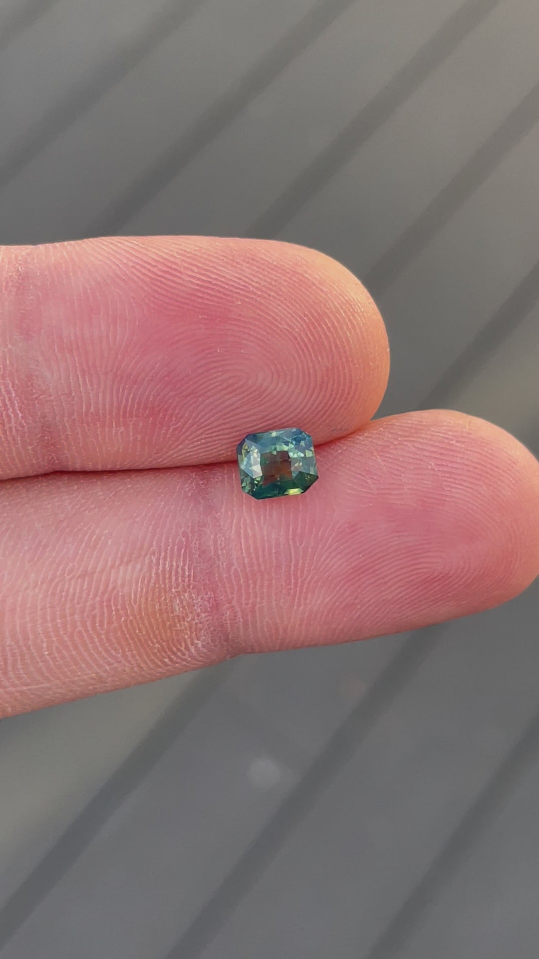 A video capturing the vibrant color play of a 1.42-carat sapphire with opalescent yellow, teal, and green tones. The radiant-cut gem is untreated and ethically sourced from Madagascar.
