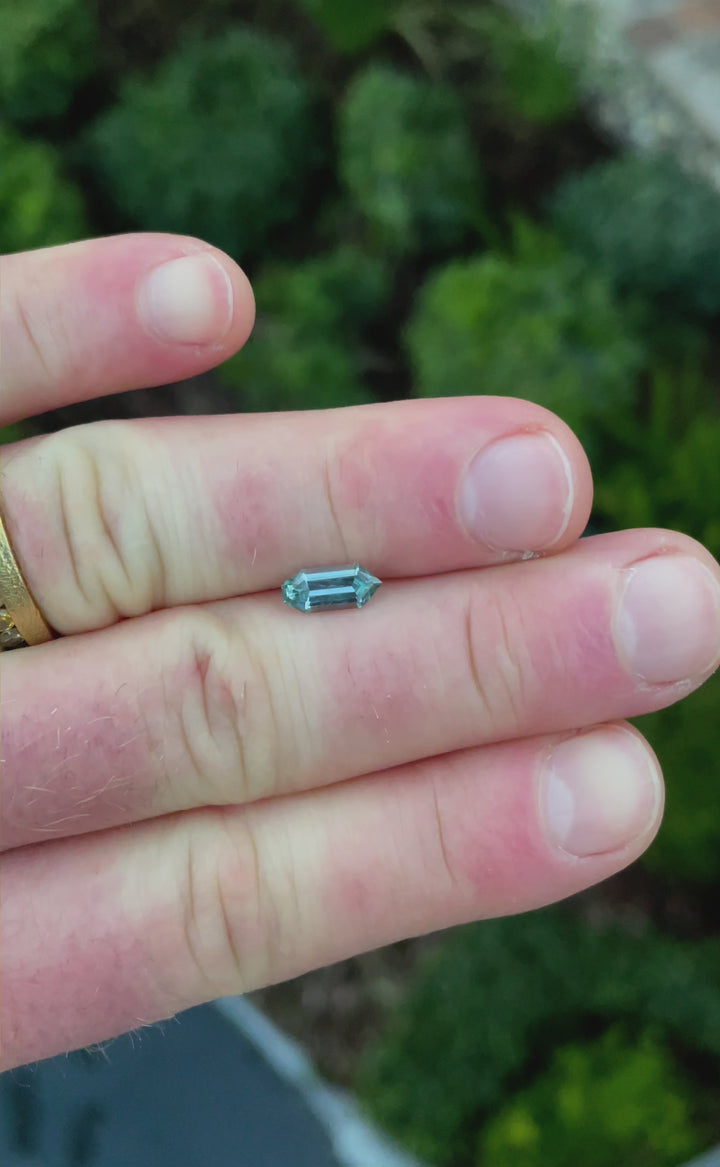 A rotating view of a 1.05 carat Montana sapphire in a unique septagon bullet cut, displaying vibrant blue, green, and teal hues with exceptional clarity and craftsmanship.