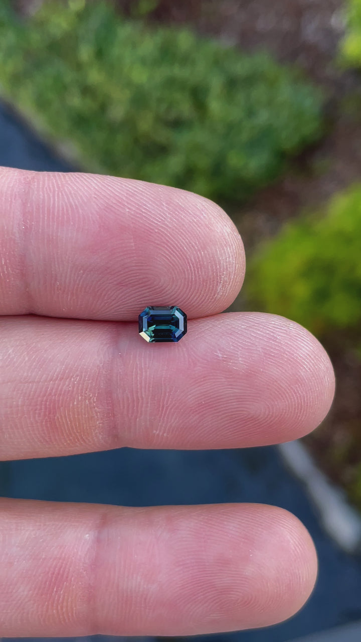 Handheld video view of a Nigerian sapphire in green and teal shades, expertly cut in an octagonal shape with step facets for maximum brilliance.