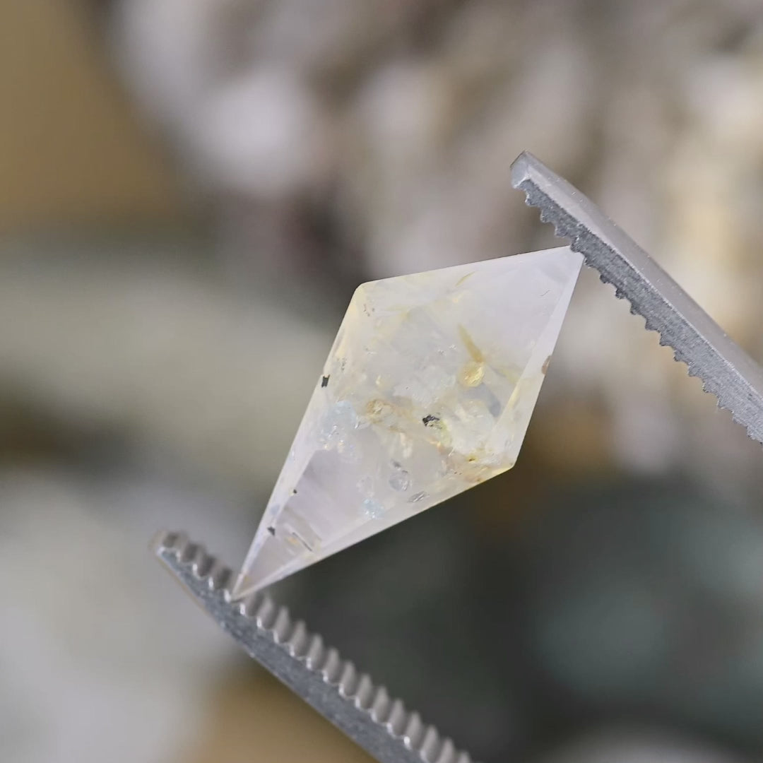 Rotating video of a 6.39ct untreated Sri Lankan sapphire showing the faceted rhombohedral cut, earthy silvery blue color, and internal features under changing light