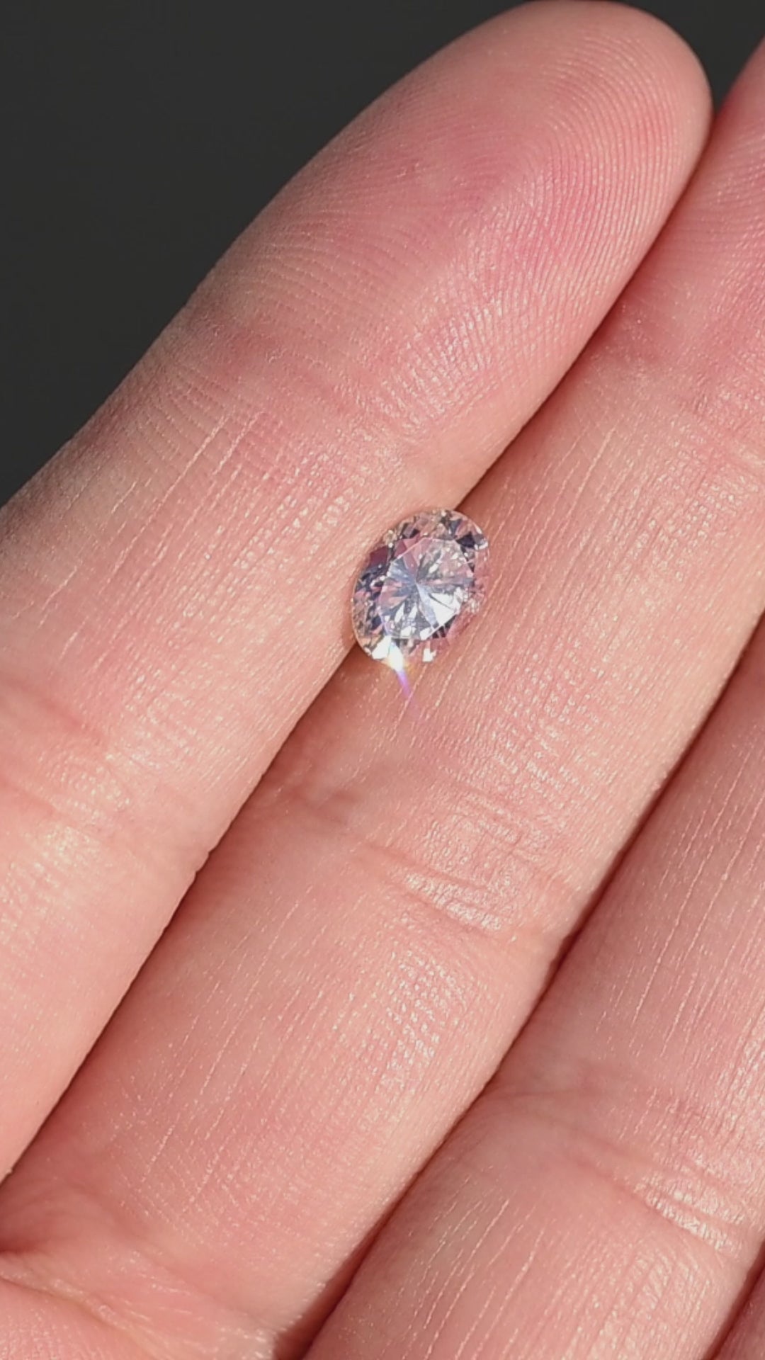 1.04ct champagne oval brilliant cut diamond from Canada rotating in hand under direct sunlight.