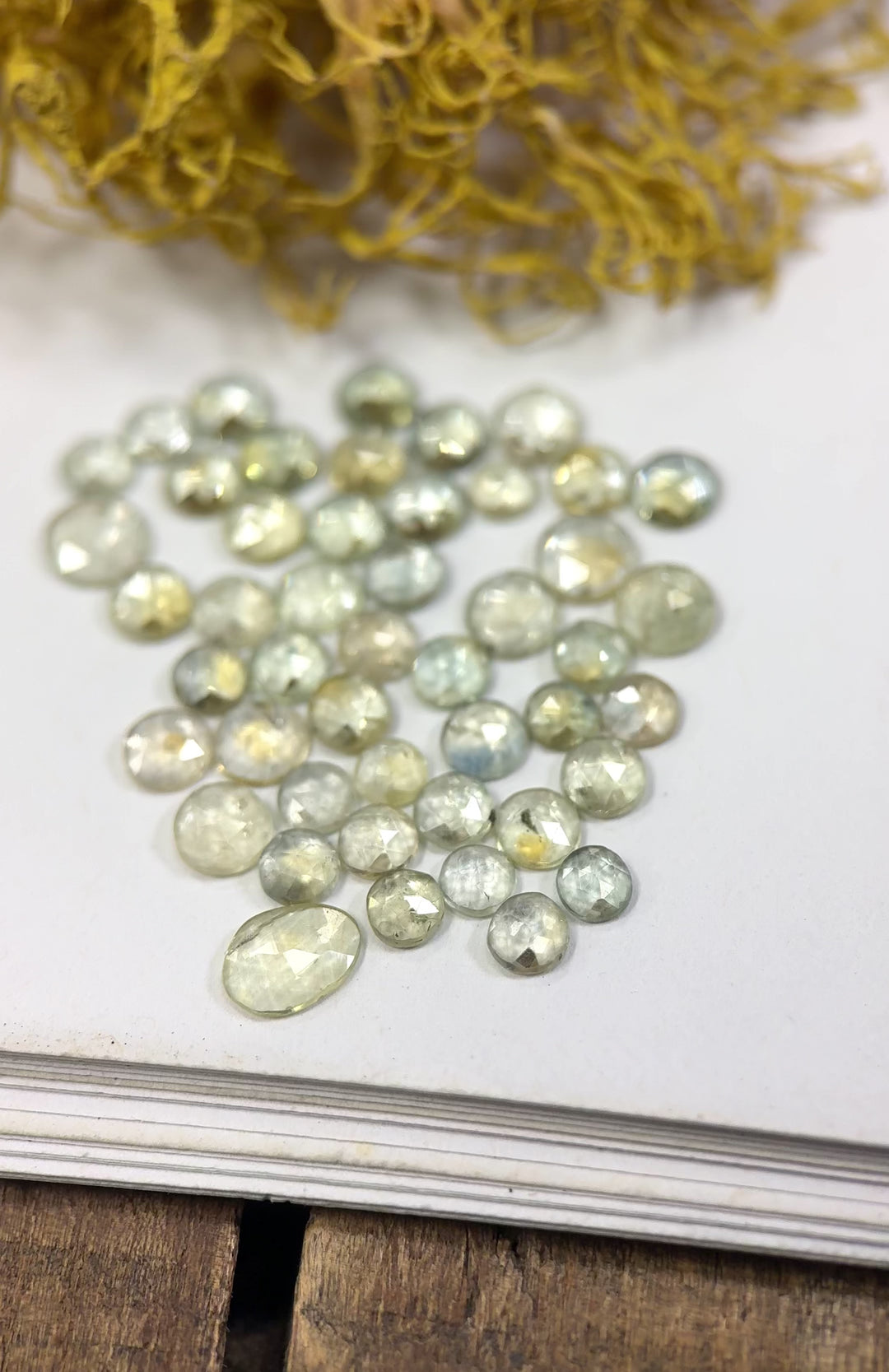 Video showcasing 47 natural seafoam teal blue green sapphires from the Eldorado Deposit, Montana, gently rotating under natural light to reveal their sparkle, subtle color shifts, and rose cut brilliance, untreated gemstones totaling 10.95 carats.