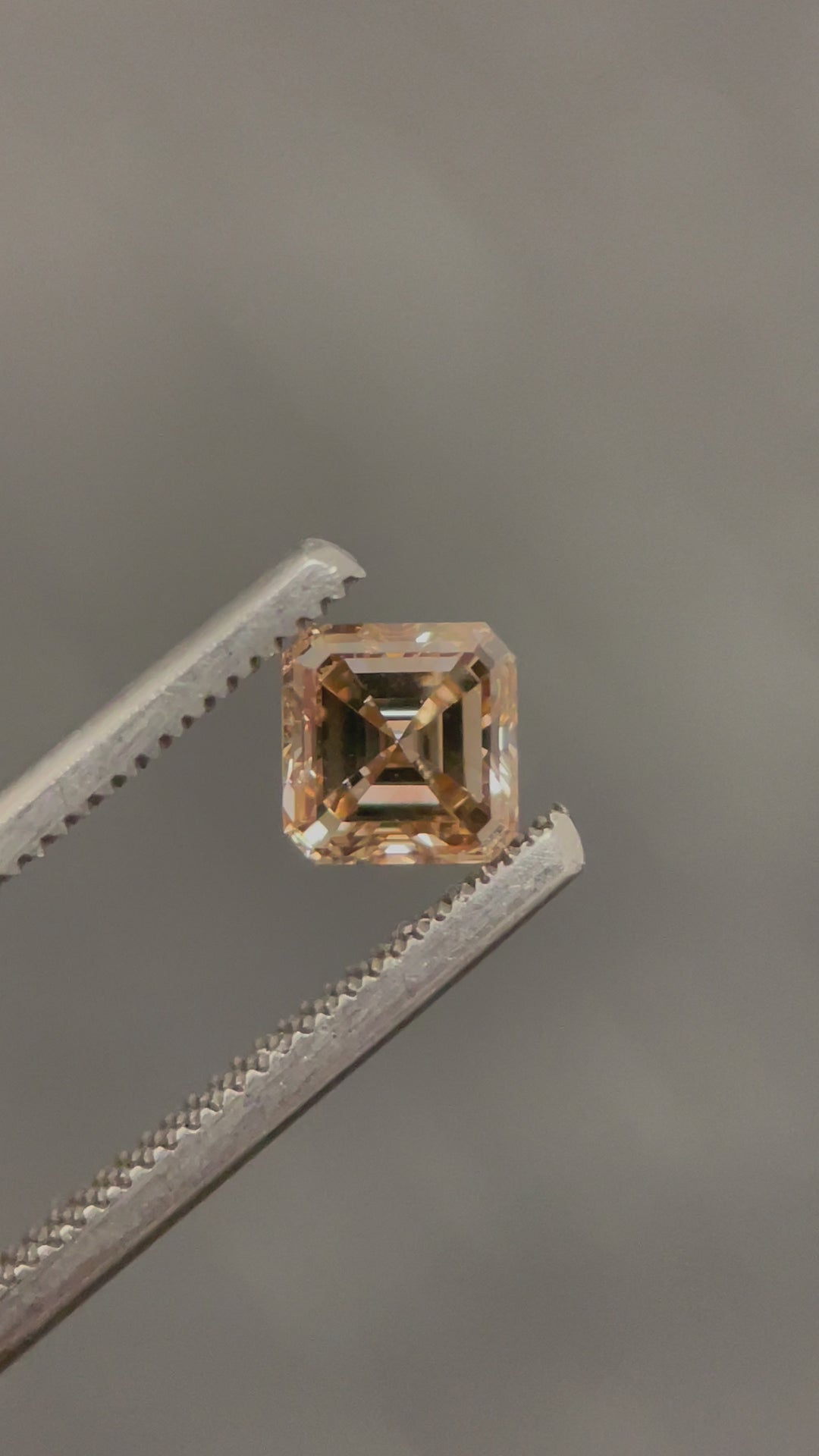 A 360-degree view of a 1.01-carat Asscher cut diamond in a champagne fancy brown hue, showcasing its mesmerizing step-cut facets and brilliant clarity (VS2) under natural lighting.