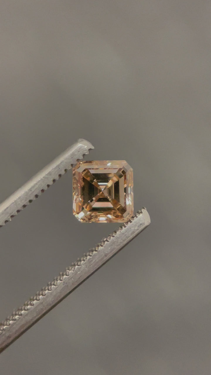 A 360-degree view of a 1.01-carat Asscher cut diamond in a champagne fancy brown hue, showcasing its mesmerizing step-cut facets and brilliant clarity (VS2) under natural lighting.