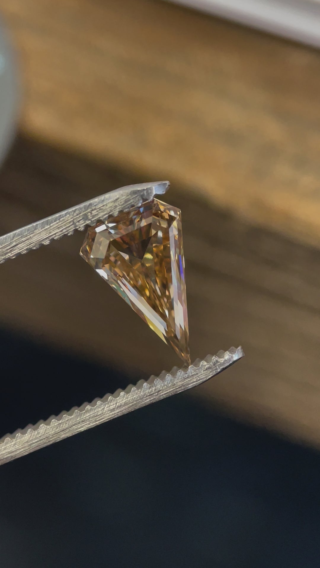 Close-up video of a 2.10-carat fancy brown diamond in a unique kite cut, reflecting brilliant light under different angles.